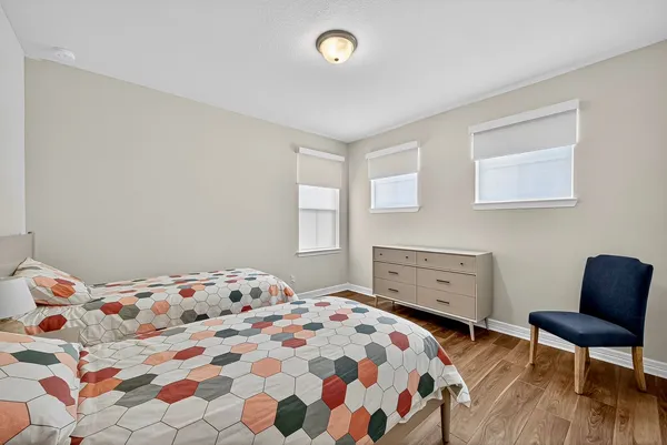 a bedroom with two beds and wooden floor