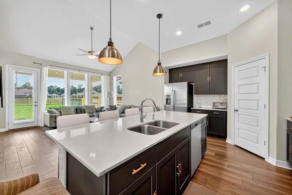 a kitchen with stainless steel appliances granite countertop a sink a stove top oven a counter space and cabinets