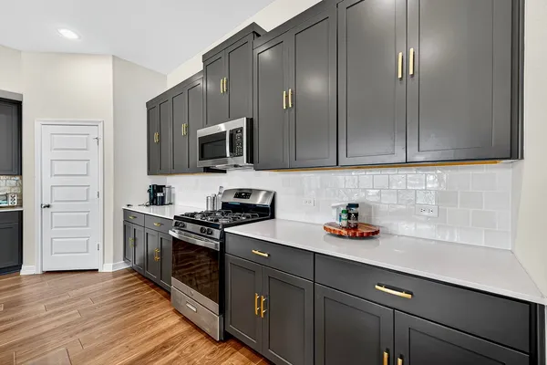 a kitchen with a dining table chairs a sink dishwasher a kitchen island with wooden cabinets and floor