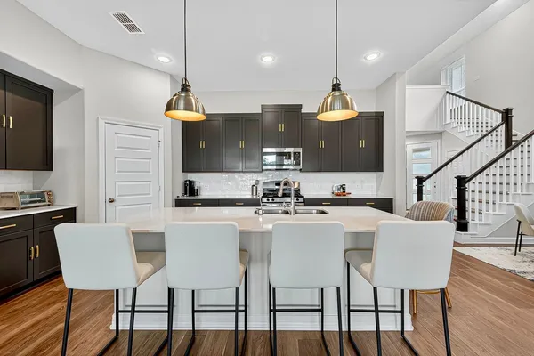 a kitchen with a sink a counter space appliances and cabinets