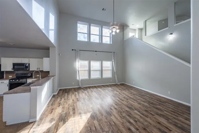 wooden floor in an empty room with a kitchen