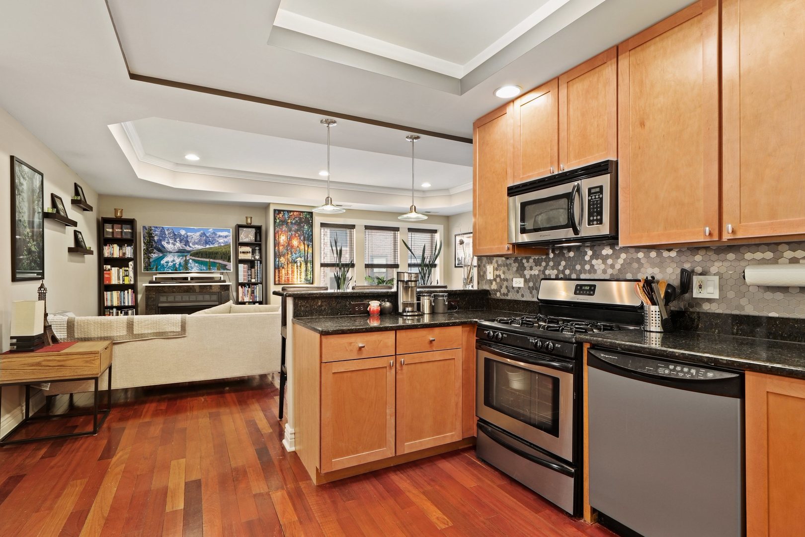 528 West Cornelia Avenue, Unit 2N Chicago, IL 60657 - Photo 8 of 19 a kitchen with stainless steel appliances kitchen island granite countertop a stove a sink and a microwave