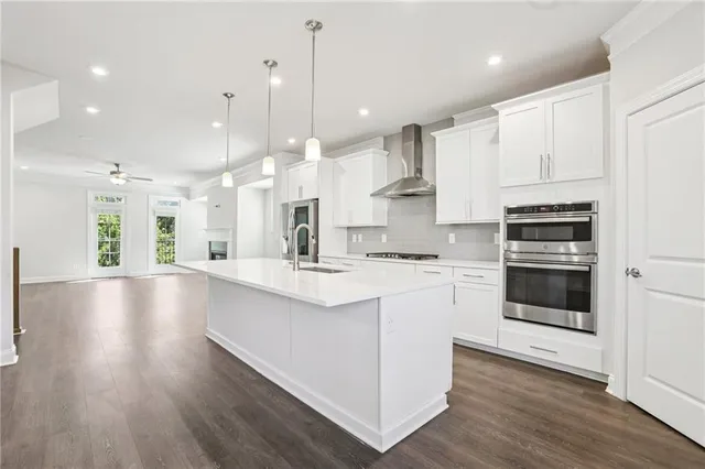 a large kitchen with stainless steel appliances kitchen island granite countertop a stove a sink a refrigerator and a wooden cabinets