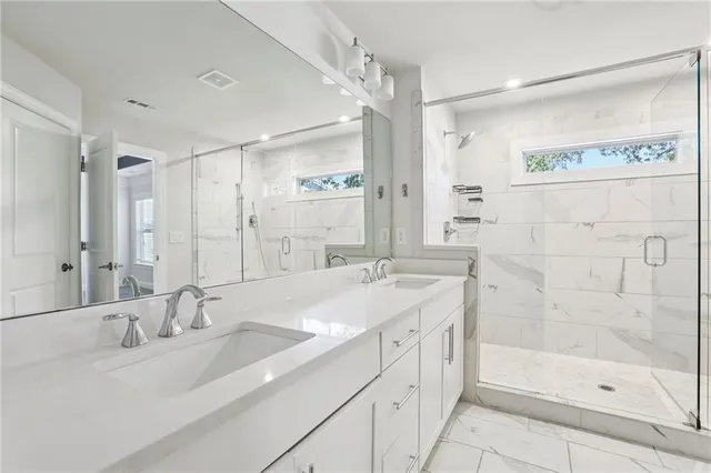 a bathroom with a double vanity sink mirror double and shower