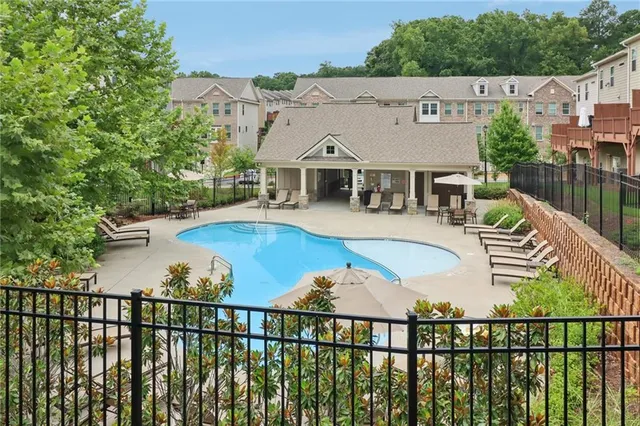 a view of a big house with a big yard and potted plants and large trees