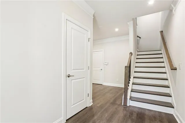 a view of a hallway with wooden floor and entryway