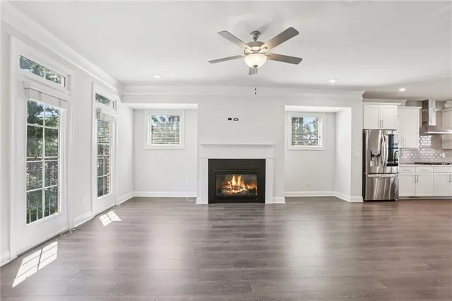 a view of a livingroom with a fireplace wooden floor and windows