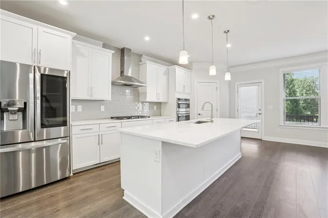 a kitchen with kitchen island a sink and a refrigerator