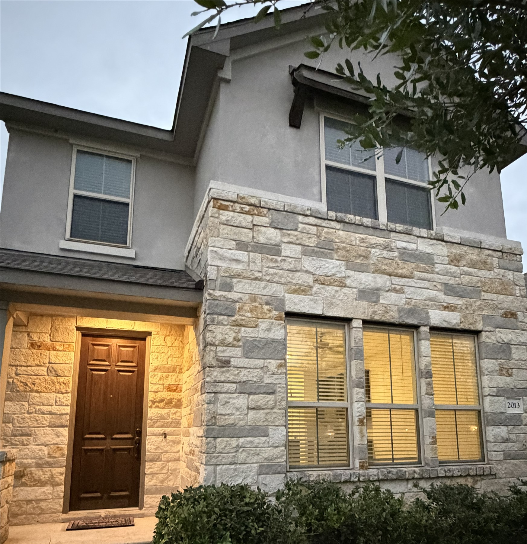 Entrance to property with stone siding and stucco siding