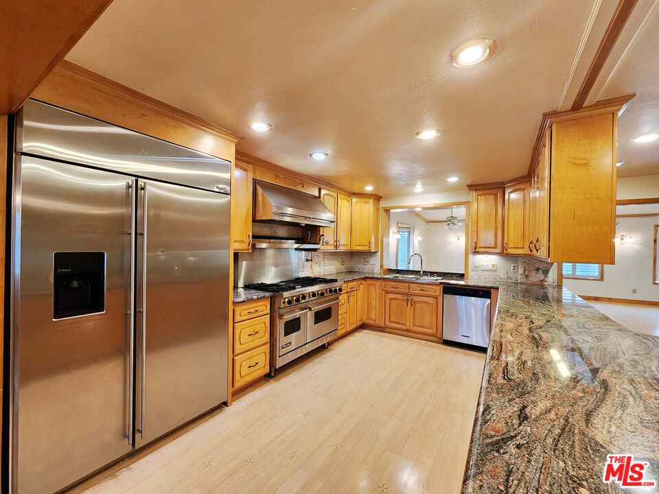 19002 Grandee Avenue Carson, CA 90746 - Photo 12 of 42 a large kitchen with stainless steel appliances kitchen island granite countertop a refrigerator and a stove top oven