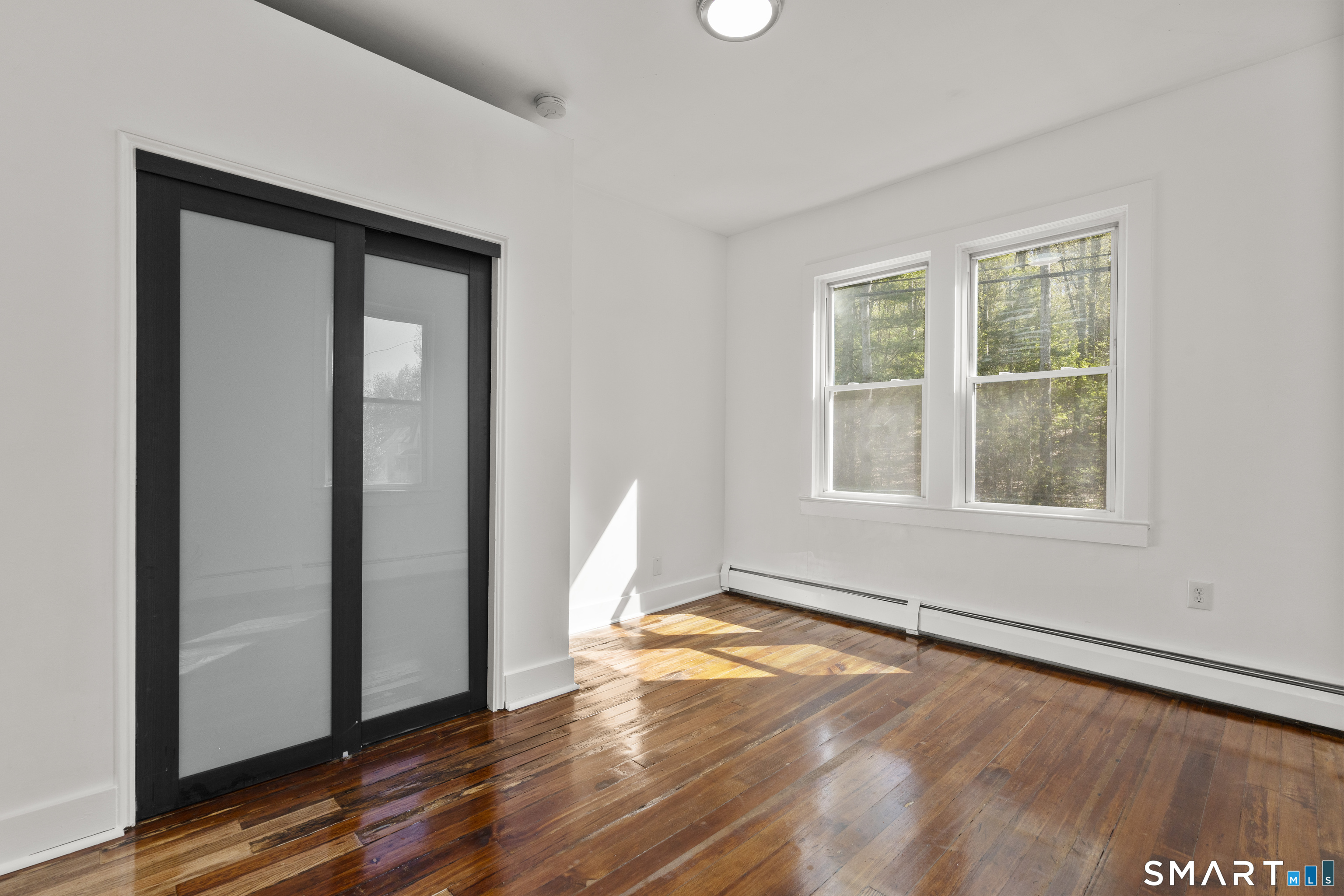 1847 Glasgo Road Griswold, CT 06351 - Photo 6 of 38 an empty room with wooden floor and windows