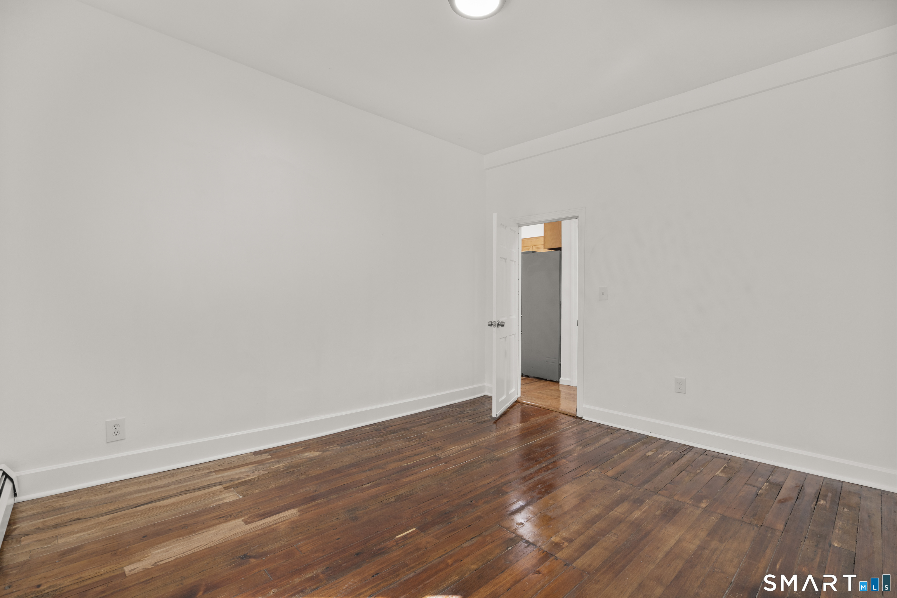 1847 Glasgo Road Griswold, CT 06351 - Photo 10 of 38 a view of an empty room with wooden floor and a window