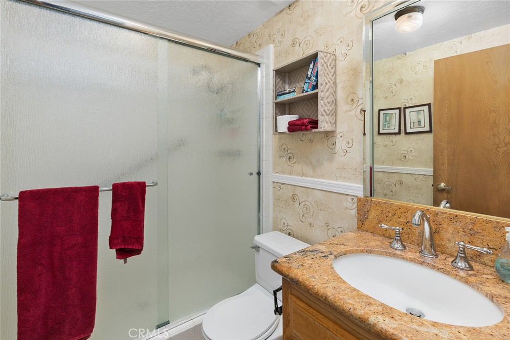 2376 North Vallejo Way Upland, CA 91784 - Photo 27 of 37 a bathroom with a granite countertop sink a toilet and shower