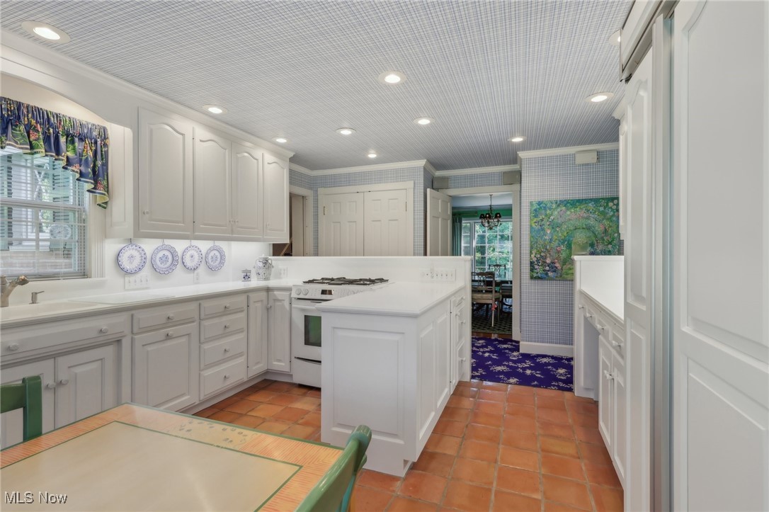2060 Stockbridge Road Akron, OH 44313 - Photo 13 of 41 Kitchen featuring ornamental molding, white cabinets, light tile patterned flooring, and gas range gas stove