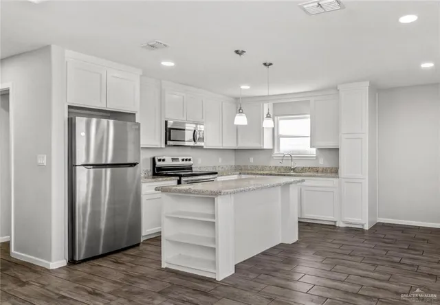 a kitchen with a refrigerator stove and wooden cabinets