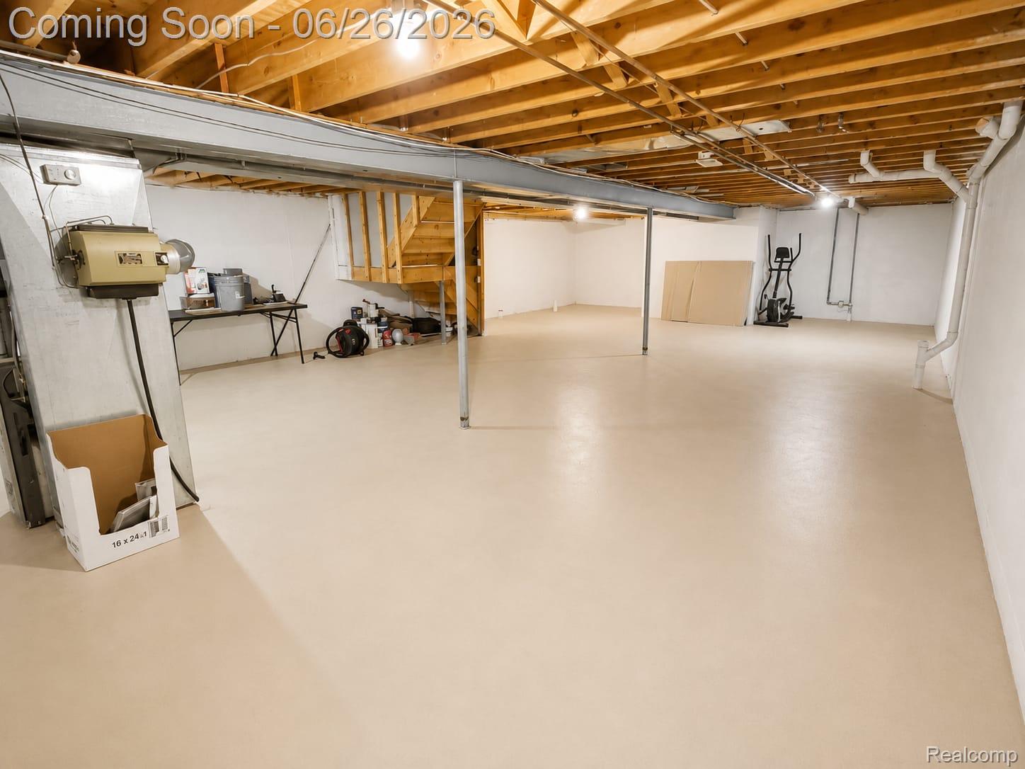 17014 Country Ridge Lane Macomb, MI 48044 - Photo 22 of 25 Expansive unfinished basement featuring a light-toned concrete floor, white painted foundation walls, exposed wood ceiling joists, and a visible wood staircase