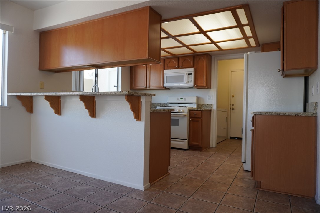 8328 Del Rey Avenue Las Vegas, NV 89117 - Photo 12 of 38 A well-appointed kitchen features ample counter space, rich wood cabinetry, and durable tile flooring.