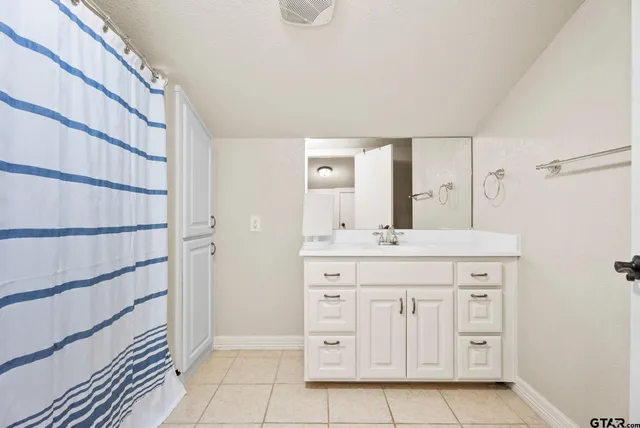 a bathroom with a granite countertop sink a mirror and a vanity