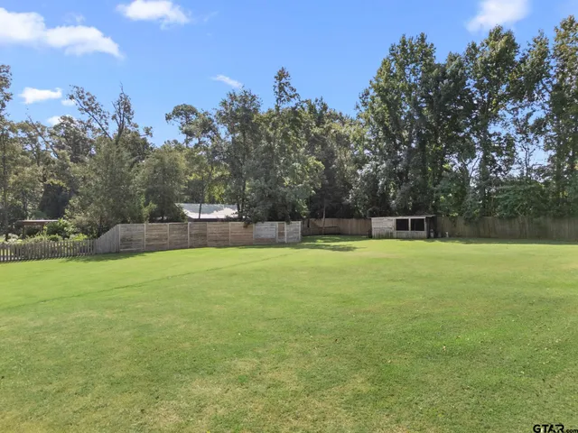 a view of a field with trees in the background