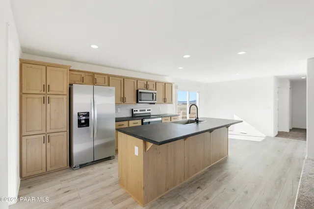 a large kitchen with granite countertop a sink and cabinets