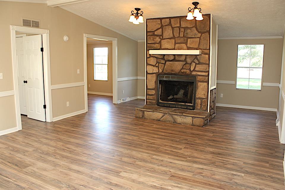 5128 Starks Road Cross Plains, TN 37049 - Photo 7 of 17 an empty room with wooden floor fireplace and windows