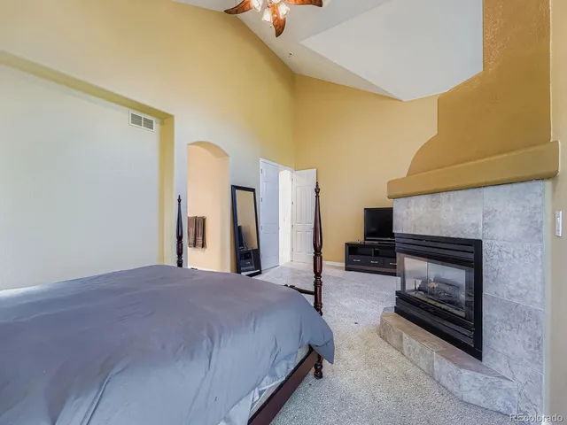 a spacious bedroom with a bed and a fireplace