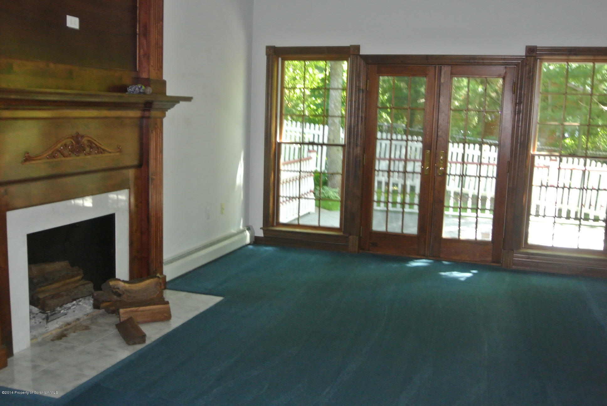 196 Point Rd Lake Factoryville, PA 18419 - Photo 8 of 36 a living room with a fireplace and large windows