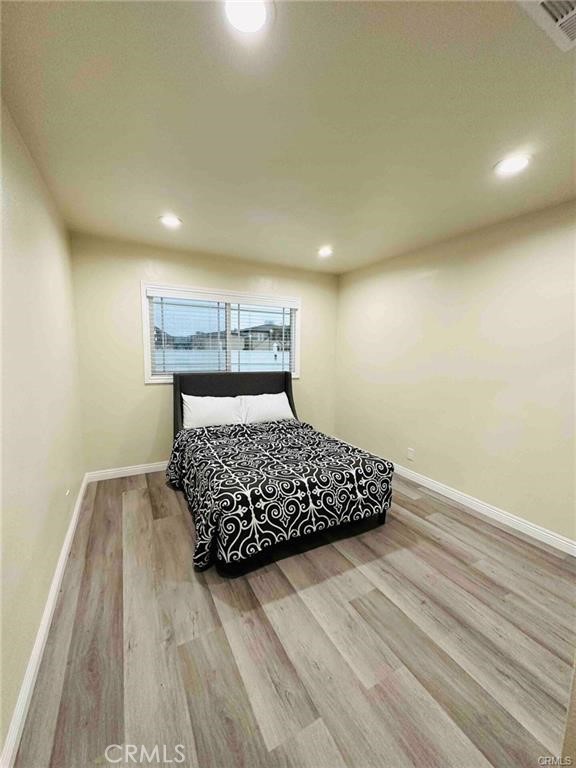 8952 McClure Avenue Westminster, CA 92683 - Photo 9 of 10 a bedroom with a bed and wooden floor