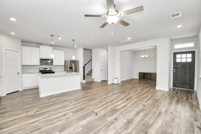 a view of kitchen with cabinets appliances and wooden floor