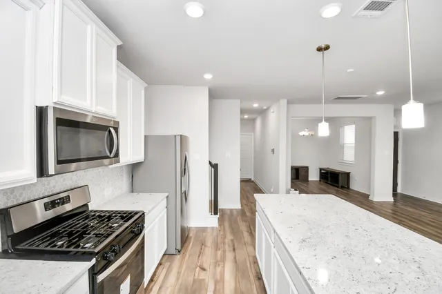 a kitchen with a stove a sink and a refrigerator