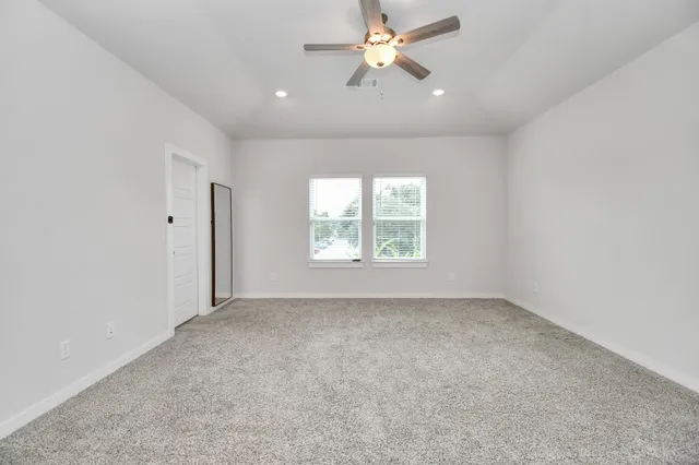 an empty room with a window and a fan
