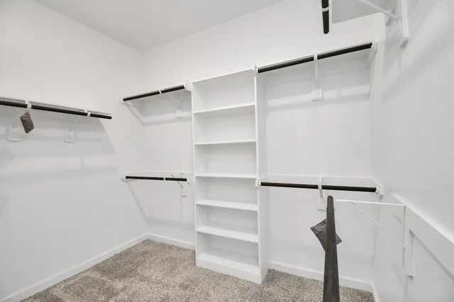 a view of walk in closet with empty racks