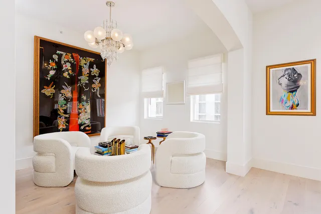 a living room with furniture a chandelier and a mirror