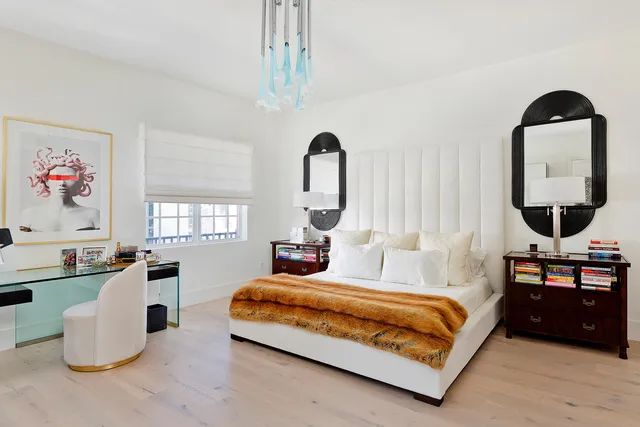 a bedroom with a bed and a dresser with mirror