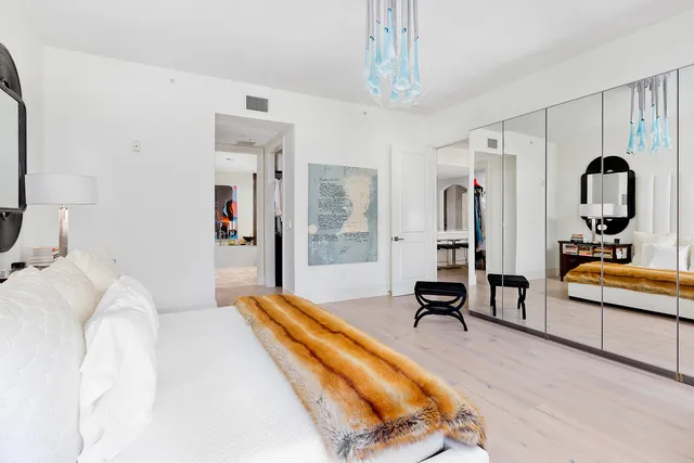 a bedroom with a bed and a chandelier