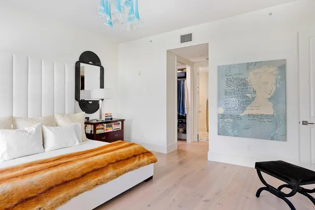 a bedroom with a large bed and a chandelier