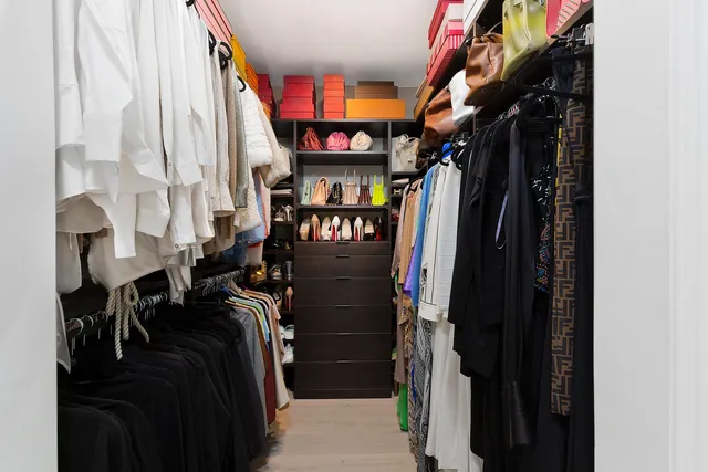 a view of walk in closet with clothes and shoes