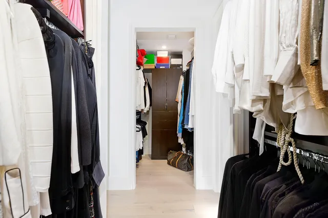 a view of walk in closet with clothes and shoes