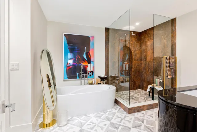 a bathroom with a tub a sink and a mirror