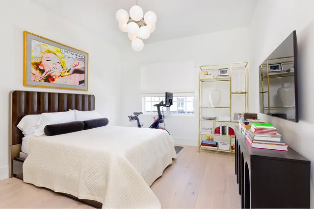 a bedroom with bed and a chandelier