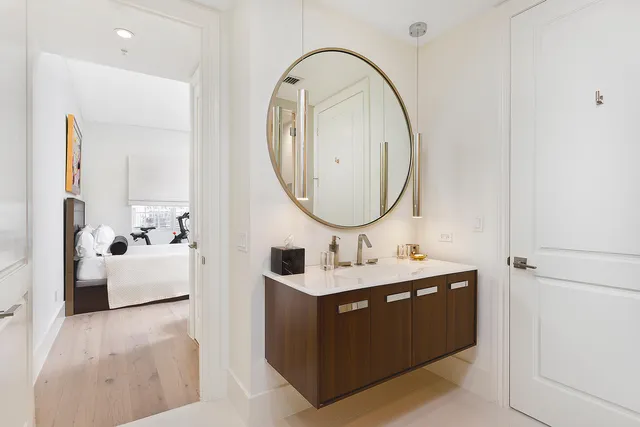 a bathroom with a sink mirror and tub