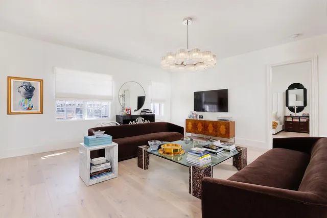 a living room with furniture kitchen view and a chandelier