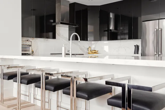 a kitchen with a sink and chairs