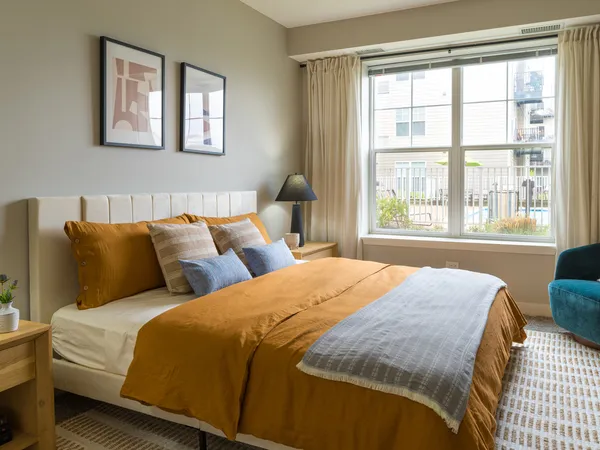 a bedroom with a bed and a large window