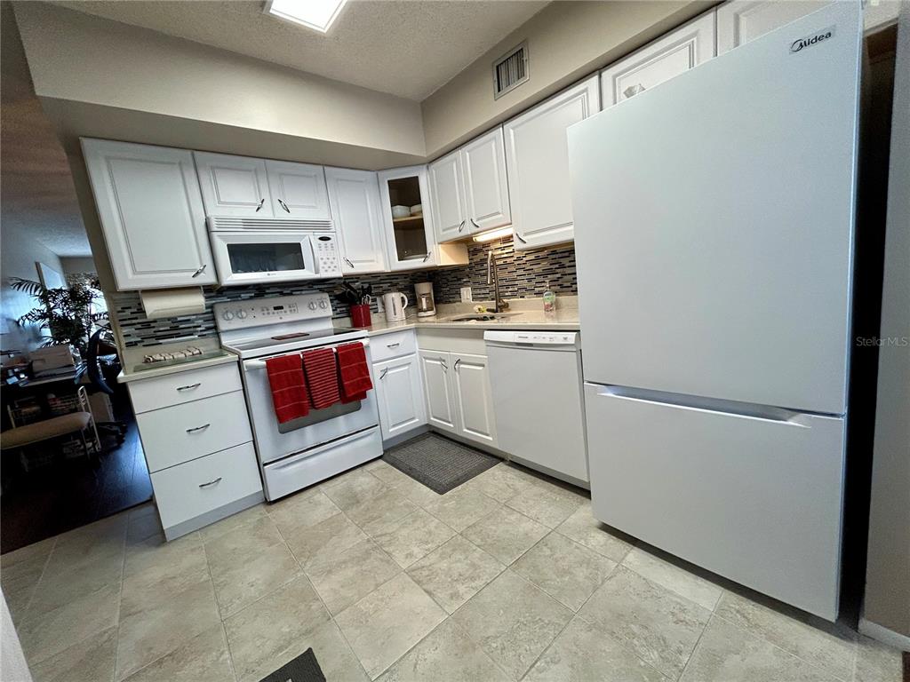 2260 Costa Rican Drive, Unit 50 Clearwater, FL 33763 - Photo 12 of 48 a kitchen with stainless steel appliances a refrigerator sink and stove