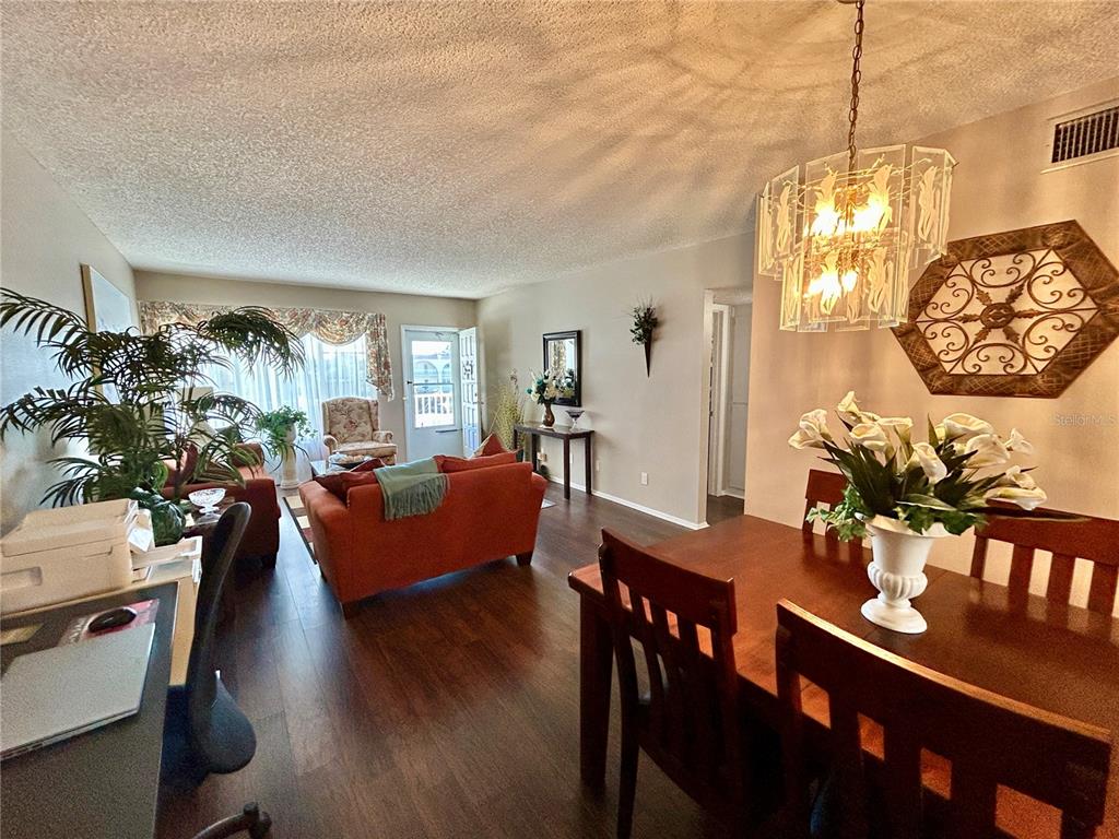 2260 Costa Rican Drive, Unit 50 Clearwater, FL 33763 - Photo 6 of 48 a living room with furniture dining table and a chandelier