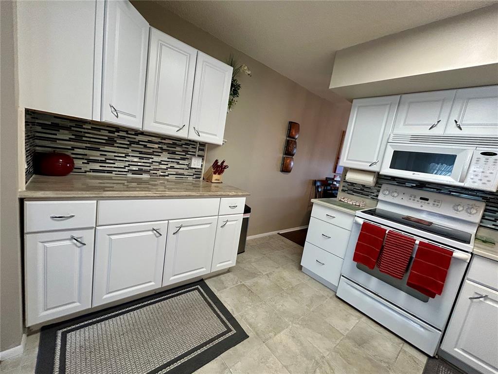 2260 Costa Rican Drive, Unit 50 Clearwater, FL 33763 - Photo 9 of 48 a kitchen with white cabinets and white appliances