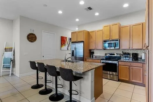 a kitchen with stainless steel appliances granite countertop a stove a sink a microwave and a refrigerator