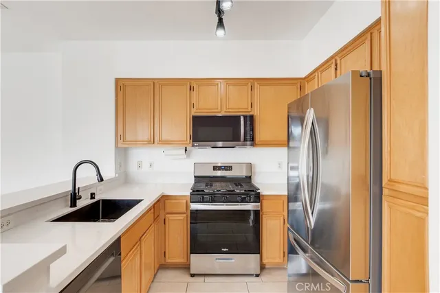 a kitchen with stainless steel appliances a refrigerator stove and sink