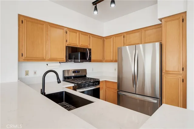 a kitchen with granite countertop a refrigerator and a stove top oven